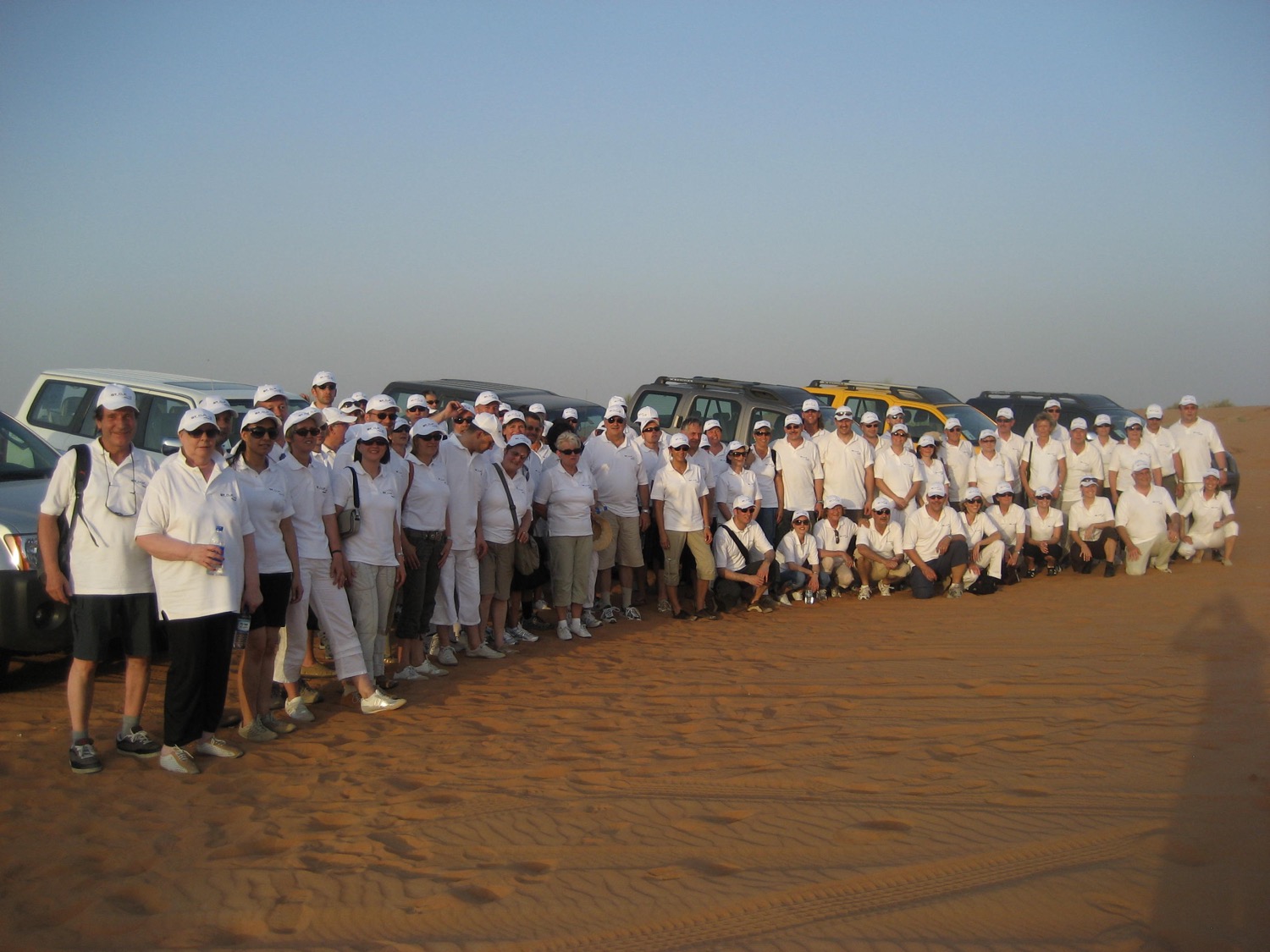 Group photo on a sandy beach during a travel program